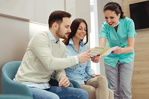 a couple being given a brochure by the dentist