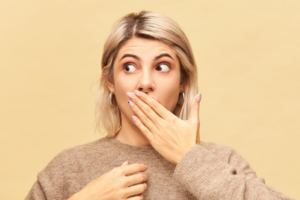 Woman covering her mouth in shock at these really strange dental emergencies